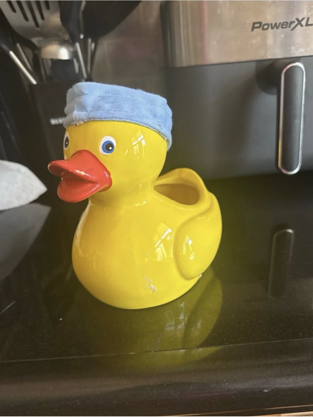 This is a vintage Teleflora glazed ceramic duck planter wearing a fabric hat.